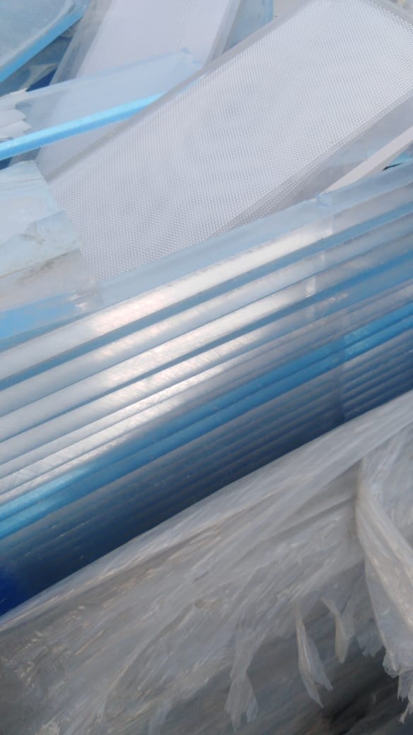 Translucent textured plastic plates stacked above crumpled film scrap