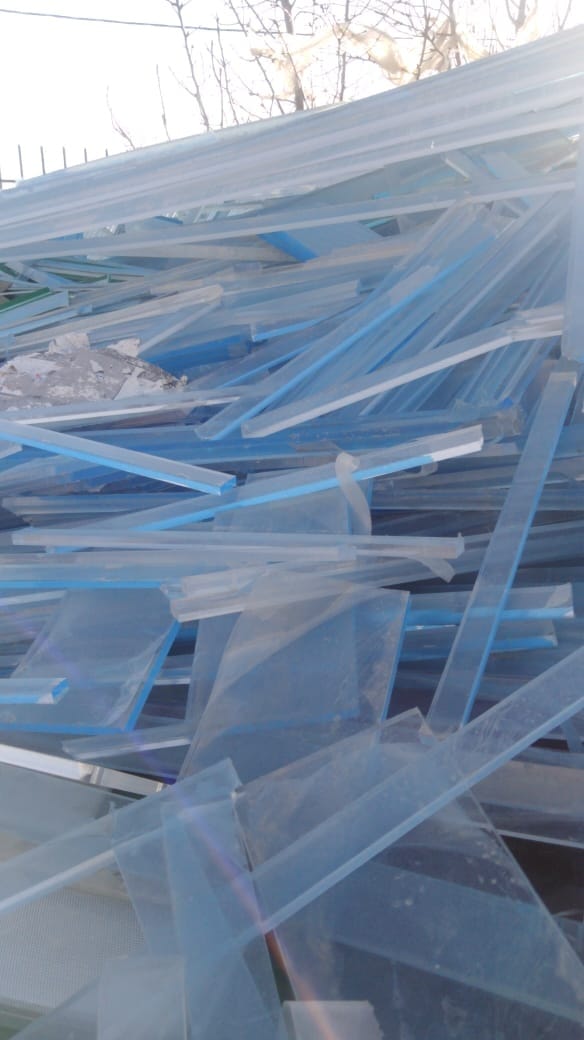 Outdoor pile of long light-blue acrylic strip offcuts