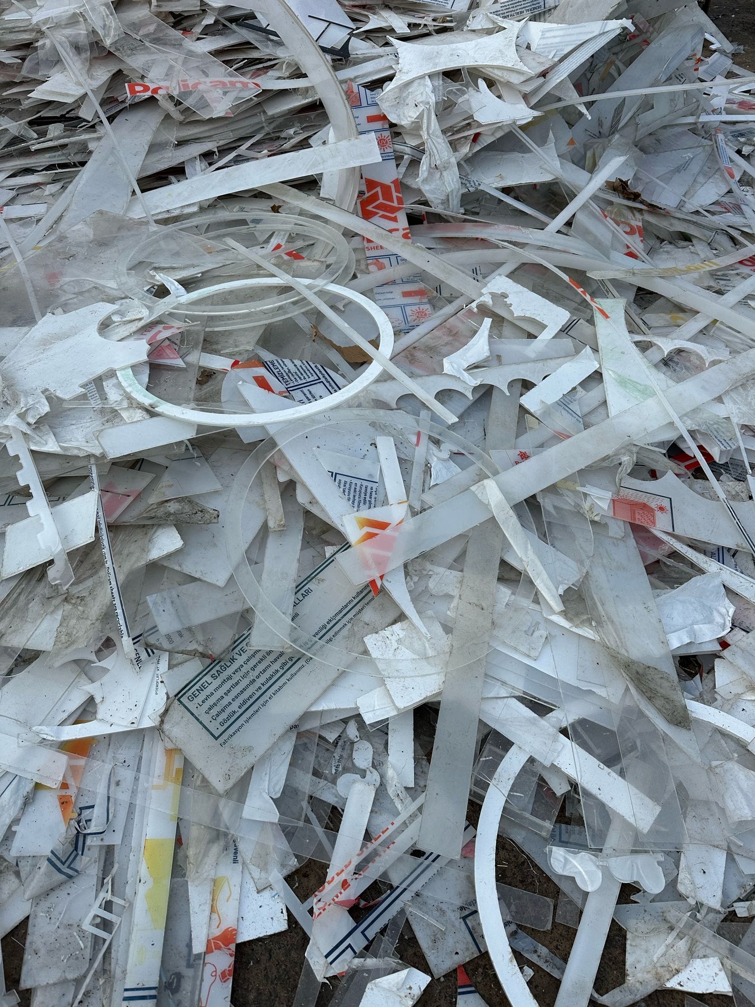 White plastic rings, strips, and printed sheet remnants from fabrication