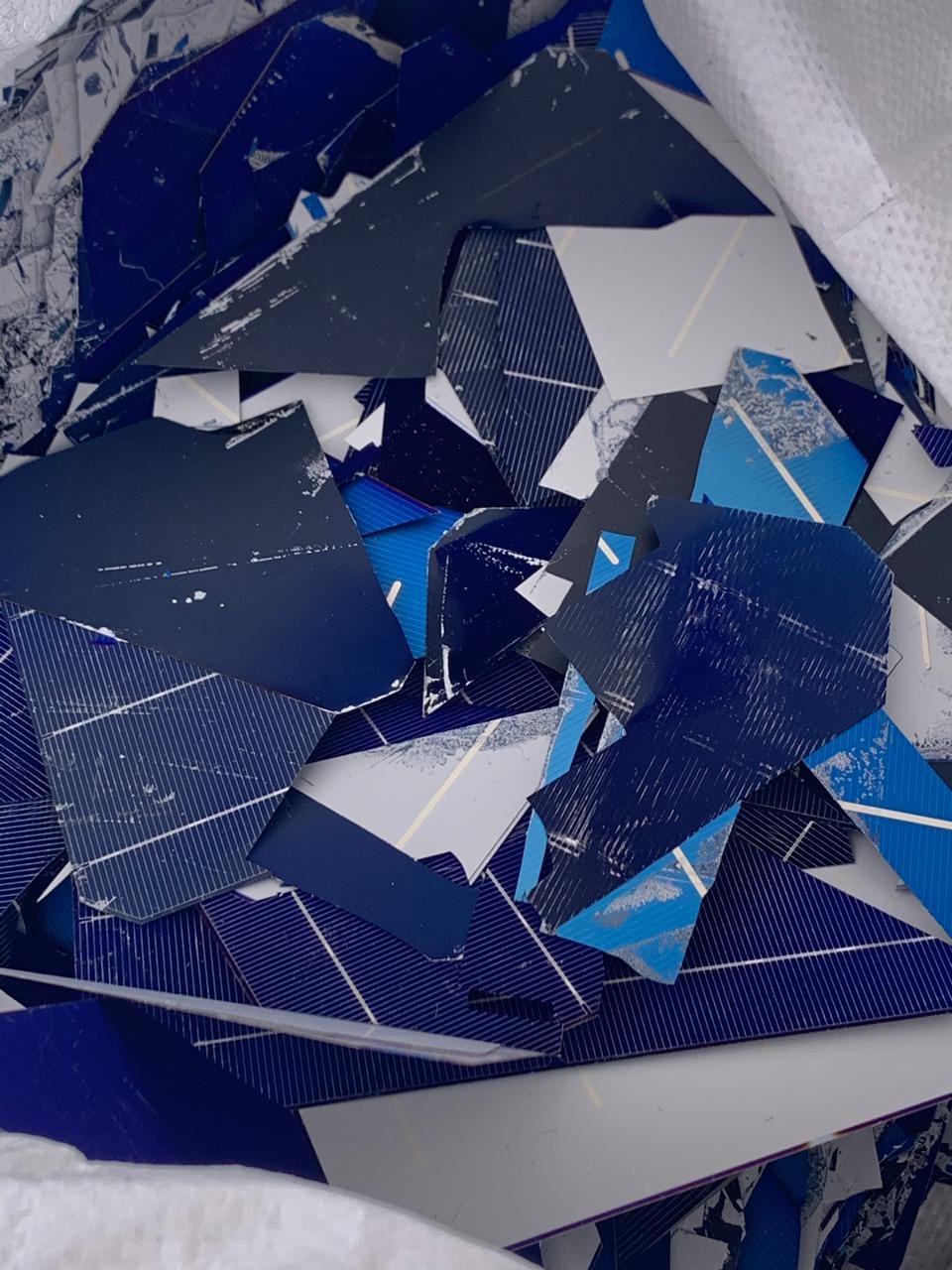 Broken blue solar cell fragments with silver grid lines in a bulk bag