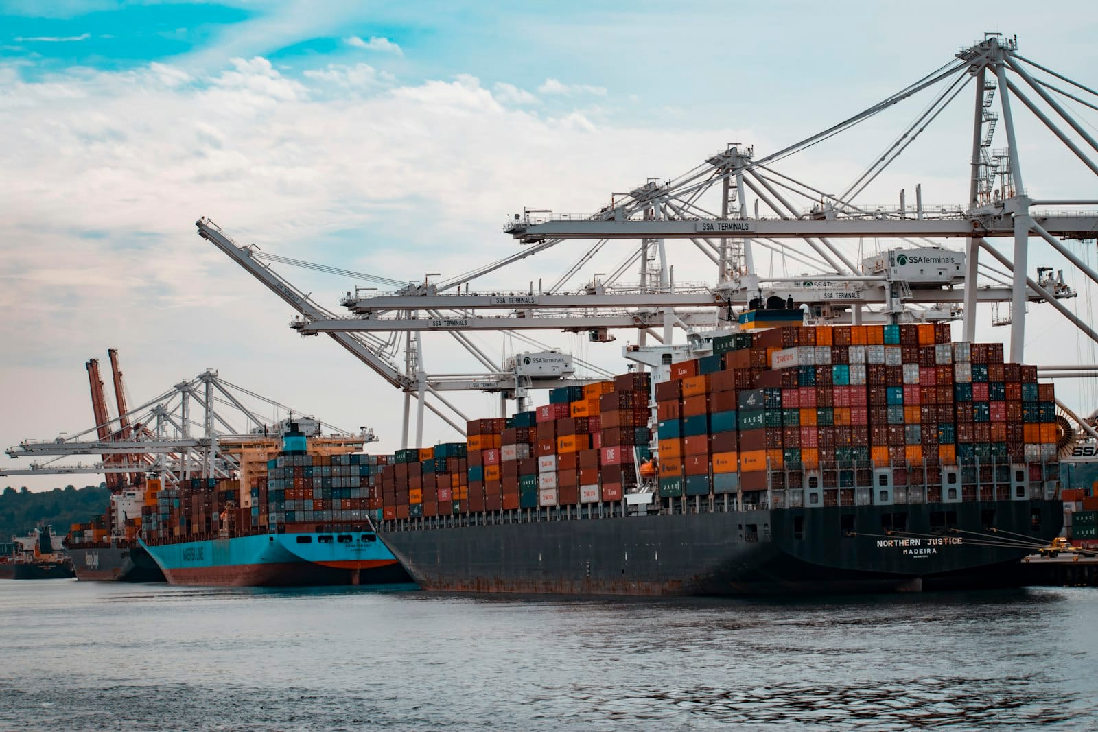 Port cranes at sunset supporting international cargo and trade logistics